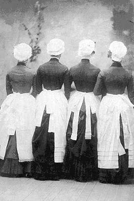 Picture of ladies wearing 4 different apron styles and caps @1885